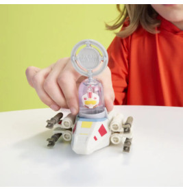 Ein Kind im roten Shirt spielt vor gelbem Hintergrund mit einem kleinen Star-Wars-Raumschiff-Spielzeug.