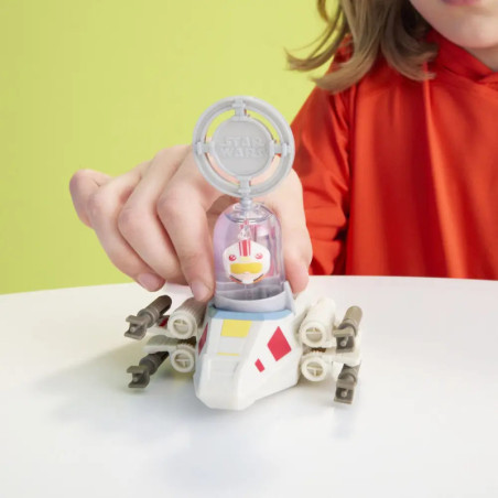 Ein Kind im roten Shirt spielt vor gelbem Hintergrund mit einem kleinen Star-Wars-Raumschiff-Spielzeug. Ein Kind im roten Shirt spielt vor gelbem Hintergrund mit einem kleinen Star-Wars-Raumschiff-Spielzeug.