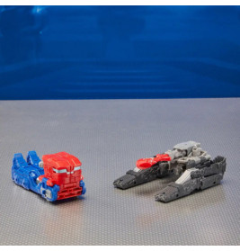 Zwei Spielzeugfahrzeuge, rot-blau und grau-schwarz, stehen auf strukturierter Fläche vor blauem Hintergrund.