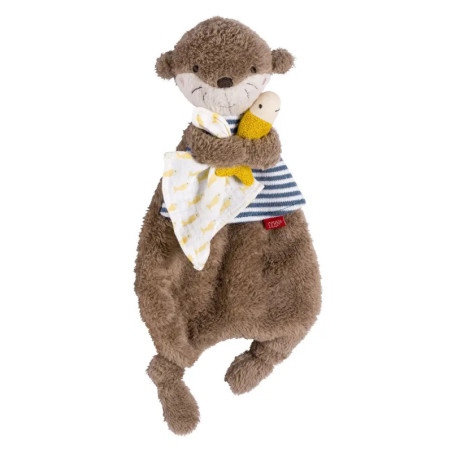 Plüsch-Otter mit gestreiftem Shirt, hält eine kleine Puppe und eine weiße Decke mit gelben Mustern.