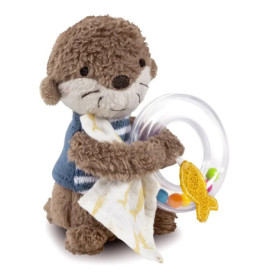 Plüschotter hält einen transparenten Rasselring mit bunten Perlen, einen gelben Fisch und ein weißes Tuch.