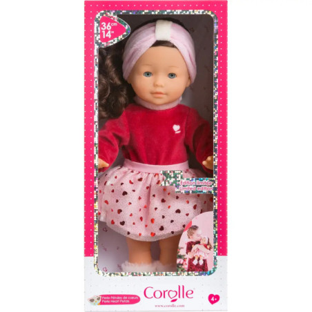 Corolle-Puppe mit Stirnband im pink-roten Outfit, präsentiert in einer pink-weißen Verpackung.