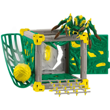 Spielzeug-Spinne auf grün-gelbem Plastikkäfig mit offener Tür und netzartigen Details.