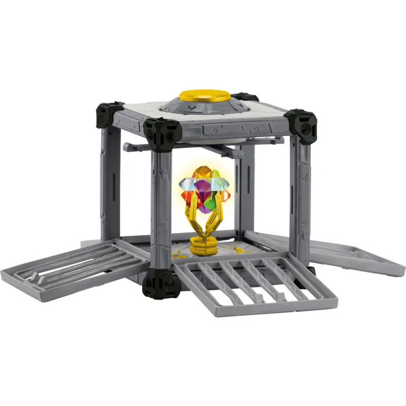 Graue Spielzeugstruktur mit offenen Seiten, in deren Mitte ein buntes, kristallartiges Objekt liegt.