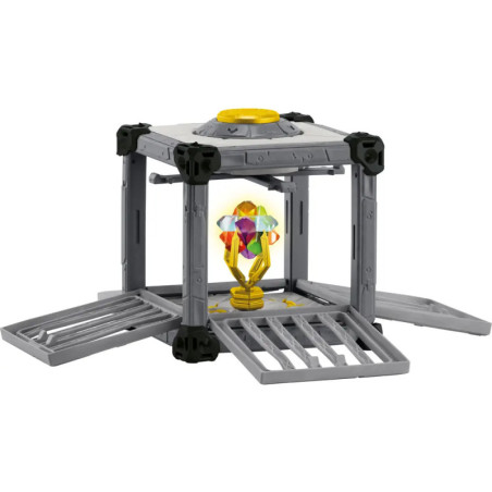 Graue Spielzeugstruktur mit offenen Seiten, in deren Mitte ein buntes, kristallartiges Objekt liegt.