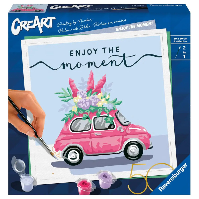 Eine Hand bemalt ein pinkes Auto mit Blumendach, darüber steht Enjoy the moment. Eine Hand bemalt ein pinkes Auto mit Blumendach, darüber steht Enjoy the moment.