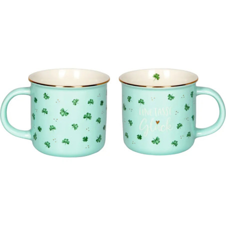 Zwei hellblaue Tassen mit grünen Kleeblättern und dem deutschen Schriftzug Eine Tasse Glück in Weiß und Gold. Zwei hellblaue Tassen mit grünen Kleeblättern und dem deutschen Schriftzug Eine Tasse Glück in Weiß und Gold.