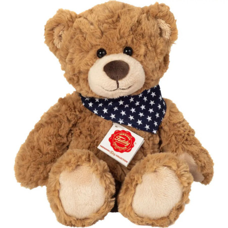 Brauner Teddybär mit blauem Halstuch und weißen Sternen sowie rotem Etikett auf der Brust. Brauner Teddybär mit blauem Halstuch und weißen Sternen sowie rotem Etikett auf der Brust.