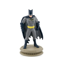 Batman-Figur im grauen Anzug mit gelbem Gürtel steht auf Podest vor weißem Hintergrund.