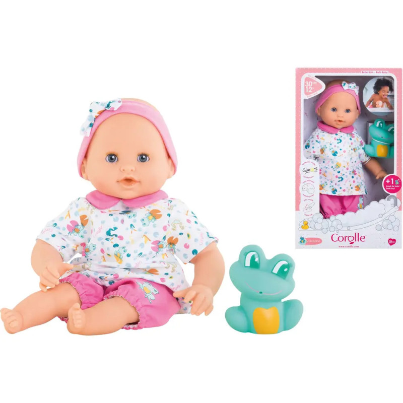 Babypuppe im bunten Outfit mit Spielzeugfrosch neben der Verpackung, die Puppe und Zubehör zeigt. Babypuppe im bunten Outfit mit Spielzeugfrosch neben der Verpackung, die Puppe und Zubehör zeigt.