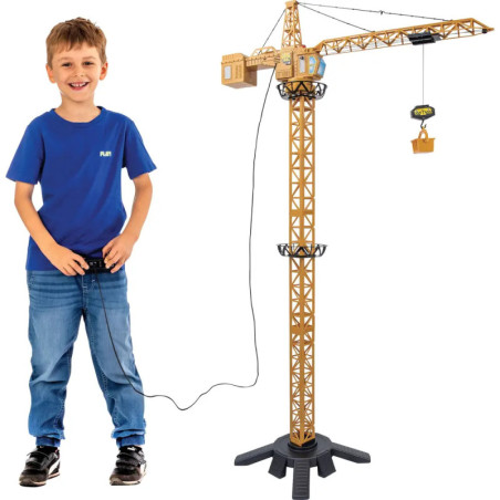 Ein Junge im blauen Hemd steuert mit einer Fernbedienung einen großen Spielzeug-Baukran.