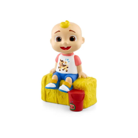 Spielzeugfigur eines lächelnden Babys mit blondem Haar sitzt auf gelbem Block neben rotem Eimer.