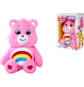 Ein rosa Care Bear Plüsch mit Regenbogen auf dem Bauch sitzt neben seiner bunten Verpackungsschachtel.