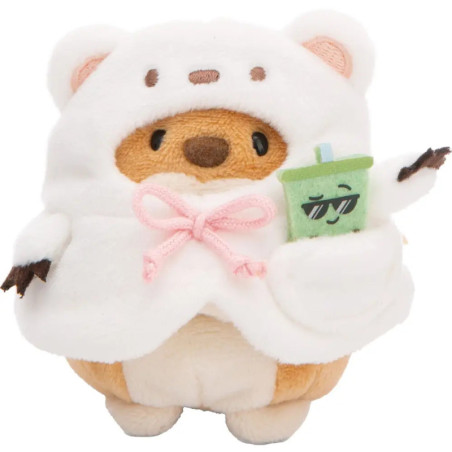 Plüschbär im weißen Hoodie trägt ein kleines grünes Plüschgetränk mit Sonnenbrille in der Tasche.