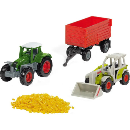 Drei Spielzeugfahrzeuge (grüner Traktor, roter Anhänger, weißer Lader) und gelbe Kunststoffpellets.