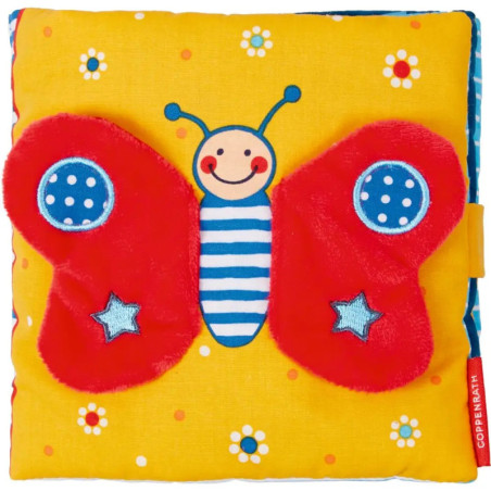 Buntes Stoffbuch mit lächelndem Schmetterling, roten Flügeln, blauen Sternen und gelbem Blumenhintergrund.