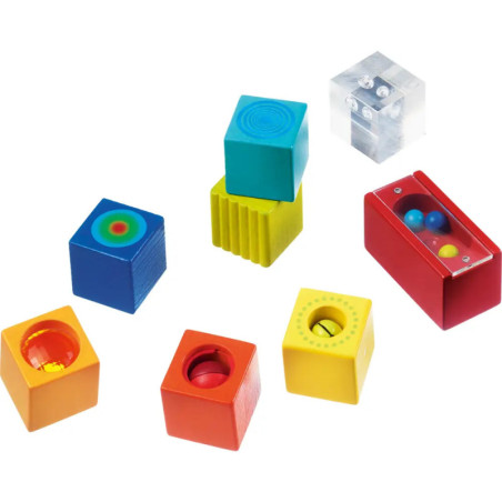 Bunte, unterschiedlich gestaltete und strukturierte Sensorikspielblöcke liegen auf weißem Hintergrund.