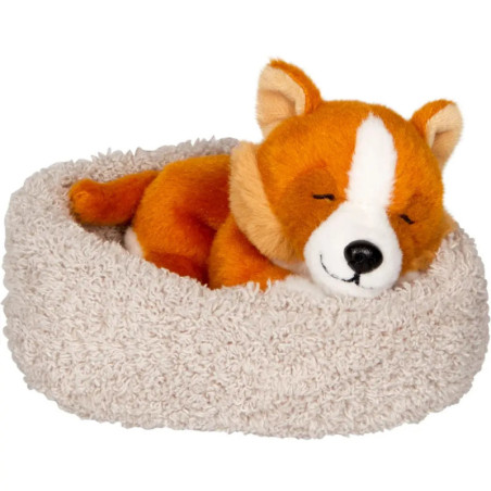 Plüschhund schläft in einem flauschigen, runden, beigen Haustierbett.