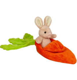 Plüschhase sitzt in einer weichen, orangefarbenen Karotte mit grünen Blättern.