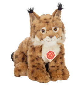 Plüschluchs mit getupftem Fell, Ohrbüscheln und rotem Halsanhänger sitzt aufrecht.