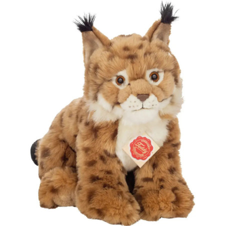 Plüschluchs mit getupftem Fell, Ohrbüscheln und rotem Halsanhänger sitzt aufrecht.