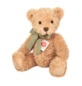 Hellbrauner Plüsch-Teddybär mit grünem Schleifenband und rotem Etikett sitzt vor weißem Hintergrund.