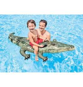 Ein Mann und ein Kind lächeln auf einem Krokodil-Pool-Float im klaren, blauen Wasser.
