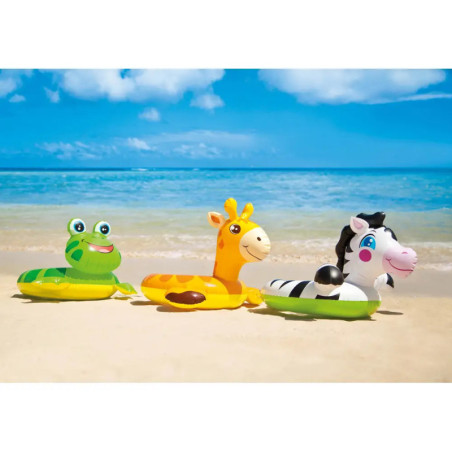 Drei Tier-Schwimmringe (Frosch, Giraffe, Zebra) am Sandstrand vor Meer und Himmel.