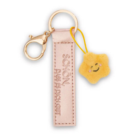 Goldener Schlüsselanhänger mit pinkem Leder-Etikett und kleinem, gelbem Stern-Anhänger mit Gesicht.