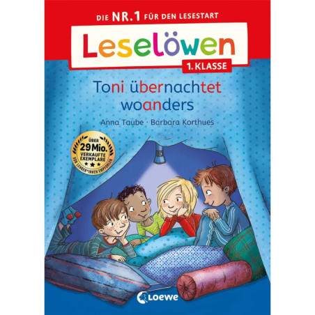 Vier Kinder sitzen lächelnd auf einem Bett in einem Fort, umgeben von Büchern und Kissen.