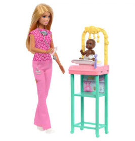 Barbie in pinker Kleidung wiegt eine lächelnde Babypuppe auf einer Spielzeugwaage unter einem Mobile.