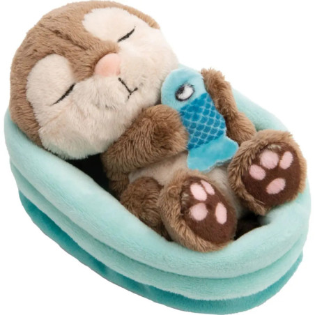 Plüschotter liegt im blauen Bett, hält einen blauen Fisch und hat geschlossene Augen.