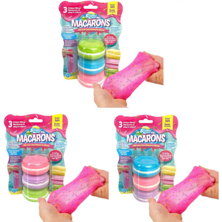 Drei Packungen Slimy Macarons, daneben Hände, die rosa Schleim auseinanderziehen. Drei Packungen Slimy Macarons, daneben Hände, die rosa Schleim auseinanderziehen.