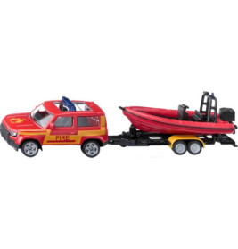 Spielzeug-Feuerwehrwagen zieht ein rotes Schlauchboot auf einen Anhänger, Seitenansicht.