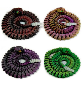 Vier gehäkelte Schlangen in Schwarz, Pink, Lila und Grün, spiralig aufgerollt, mit gelben Augen.