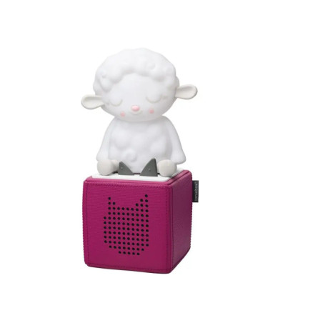 Auf einem pinken Lautsprecher mit katzenförmigem Gitter steht eine weiße Schaf-Figur.