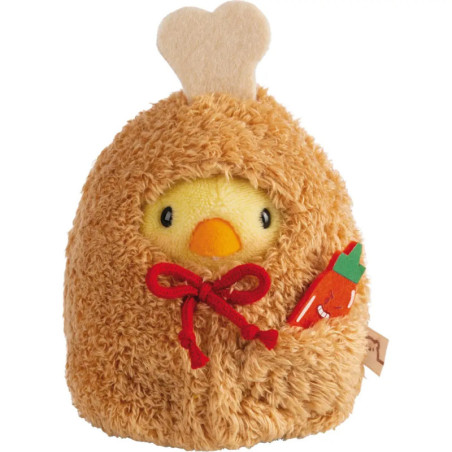 Plüsch-Küken im braunen Hühnerkostüm hält eine kleine Plüsch-Möhre.