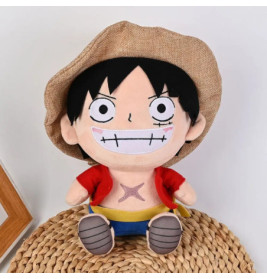 Plüschfigur eines lächelnden Anime-Charakters mit Strohhut, roter Jacke und Shorts auf einer Matte.