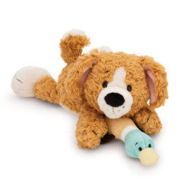 Plüschhund braun liegt, hält ein blau-beiges Stoff-Entenküken im Maul.