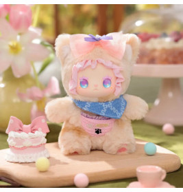 Plüschfigur mit pastellfarbener Schleife und Lätzchen steht auf Tisch neben Kuchen, Blumen und Deko.