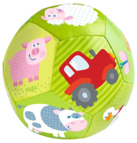 Grüner Ball mit Comicbildern von Schwein, Kuh, Schaf, Ente und rotem Traktor auf den Flächen.