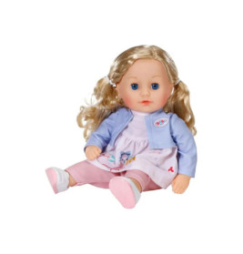 Blonde Puppe mit blauen Augen, lila Jacke, pinkem Kleid und weißen Schuhen sitzt.
