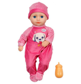 Babypuppe in rosa Outfit und Mütze mit Hundeprint liegt neben einer orangefarbenen Spielzeugflasche.