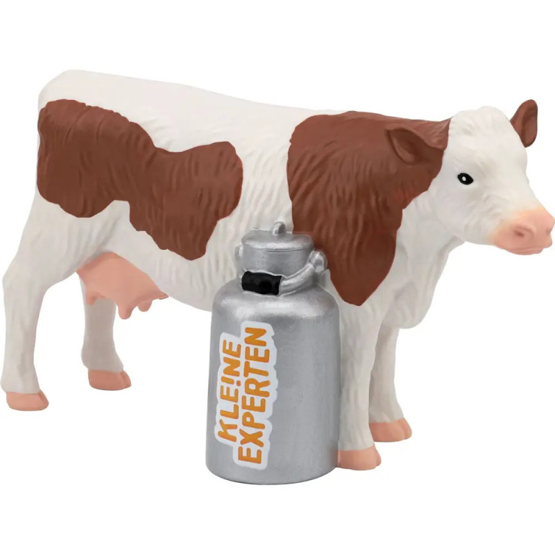 Braun-weiße Spielzeugkuh steht neben silberner Milchkanne mit der Aufschrift KLEINE EXPERTEN.