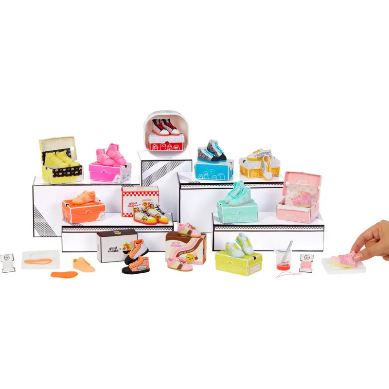 Bunte Miniaturschuhe in Boxen auf weißen Ständern, eine Hand greift nach einem Paar.