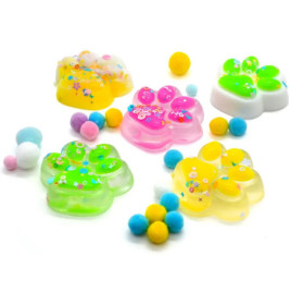 Bunte Pfoten-Seifen mit Blumenmuster und kleinen pastellfarbenen Pompons auf weißem Hintergrund.