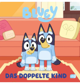 Bluey und ein weiterer Blue Heeler stehen lächelnd im Wohnzimmer. Text: Bluey Das Doppelte Kind.