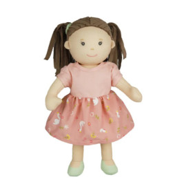 Weiche Puppe mit braunen Zöpfen, rosa gemustertem Kleid und grünen Schuhen steht lächelnd aufrecht.