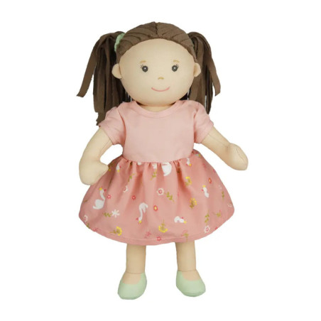 Weiche Puppe mit braunen Zöpfen, rosa gemustertem Kleid und grünen Schuhen steht lächelnd aufrecht.