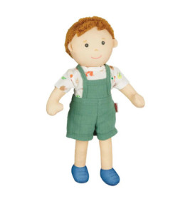Stoffpuppe mit braunen Haaren, grüner Latzhose, gemustertem weißen Shirt und blauen Schuhen.